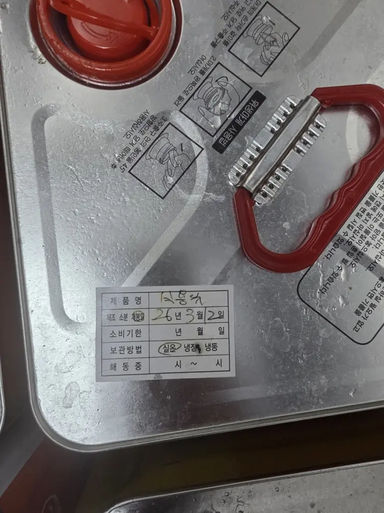식용유 캔에 부착된 제품명과 제조 정보 표시를 확인하는 확대 사진